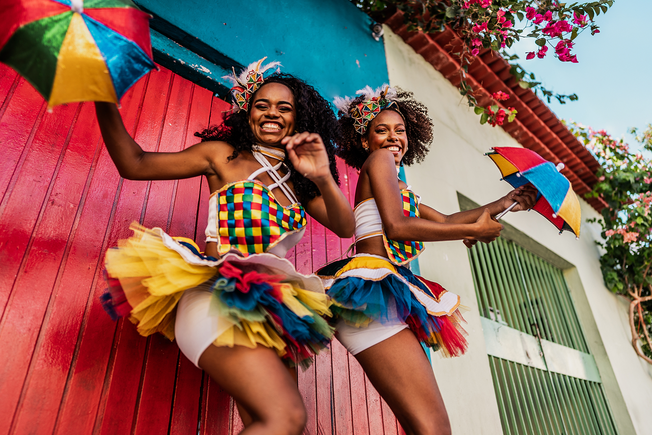 Carnival dancers celebrating with colorful umbrellas.